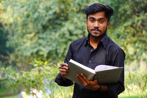 Foto student dichtbij universiteitscampus met boeken die boekenconcept lezen