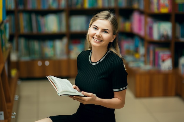 Student die een boek in de bibliotheek leest