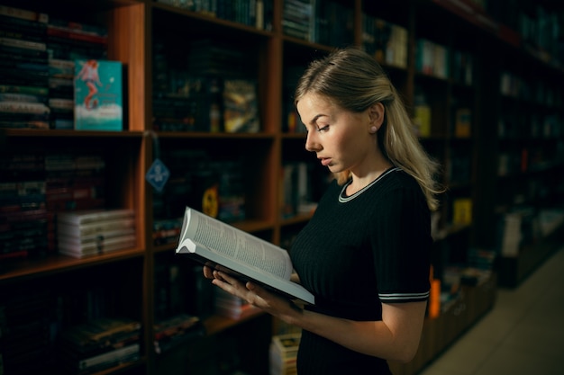 Student die een boek in de bibliotheek leest