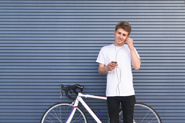 Student die zich door een fiets op de achtergrond van de muur bevindt