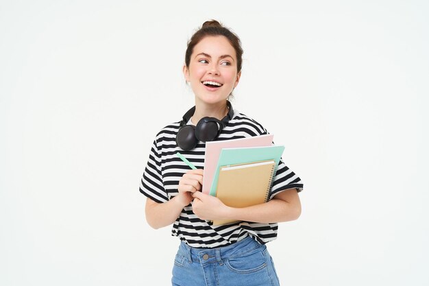 Student and education concept young woman with books notes and pen standing over white background person
