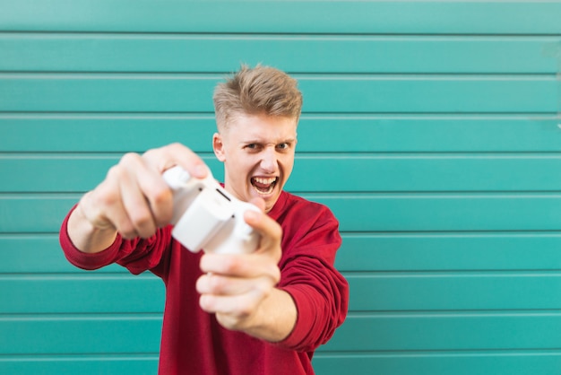 Student gamer met een gamepad in zijn handen het spelen van consolegames