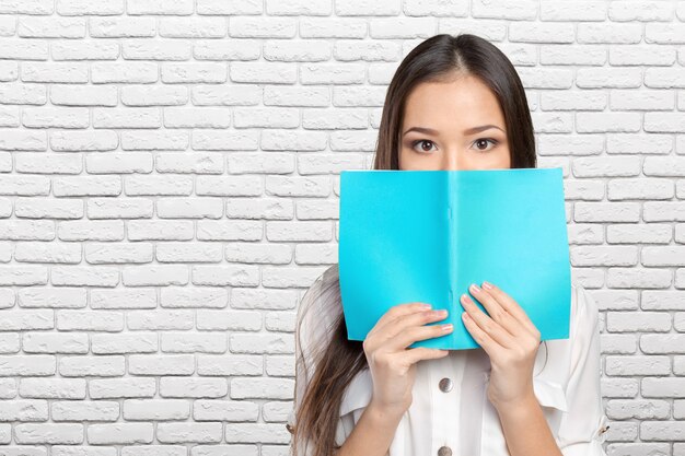 Student girl hides behind the book