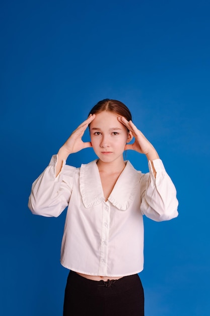 Photo student girl holding head in hands over blue background problem of choice and decisionmaking concept