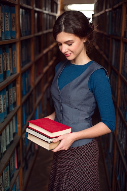 Фото Студент девушка или женщина с книгами в библиотеке.