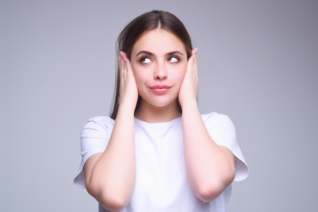 Student girl shows silence with a gesture woman isolated on gray studio background keep finger at