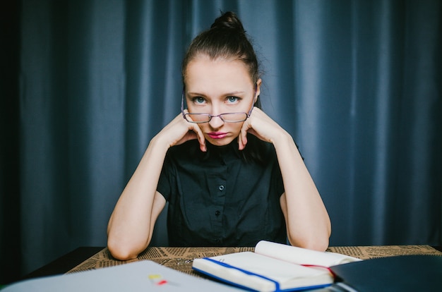 Student in glasses sitting on a table at home