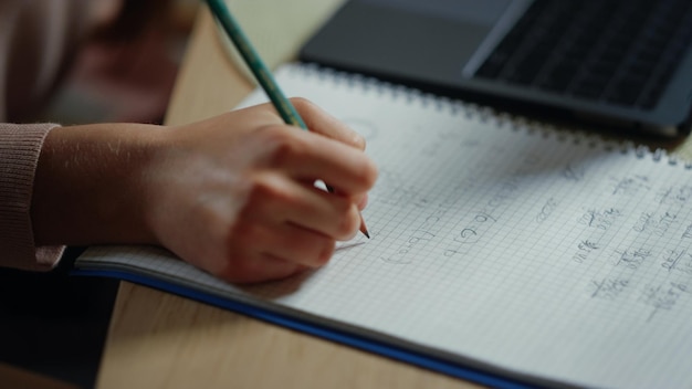 Student hand schrijven in notitieboekje binnenshuis Onbekend meisje huiswerk binnen