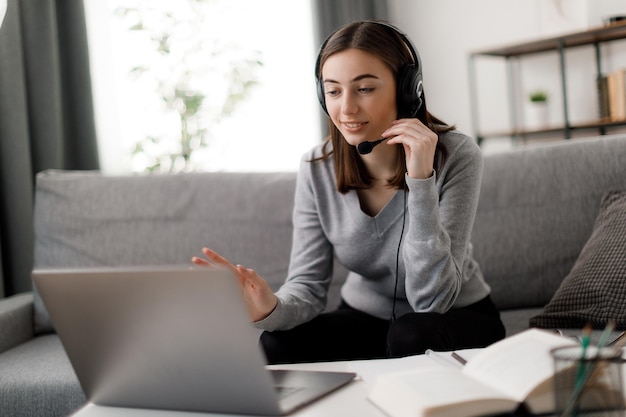 Photo student in headset using laptop