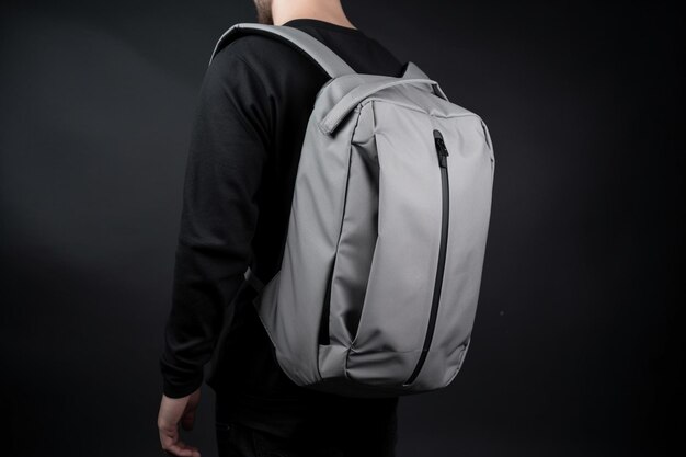 Photo student holding the grey backpack in the front