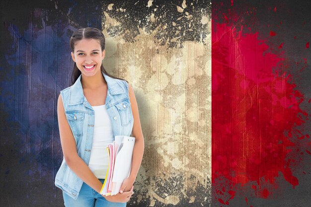 Фото Студент держит блокноты против флага франции с эффектом гранжа