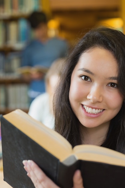 Student in bibliotheek leesboek