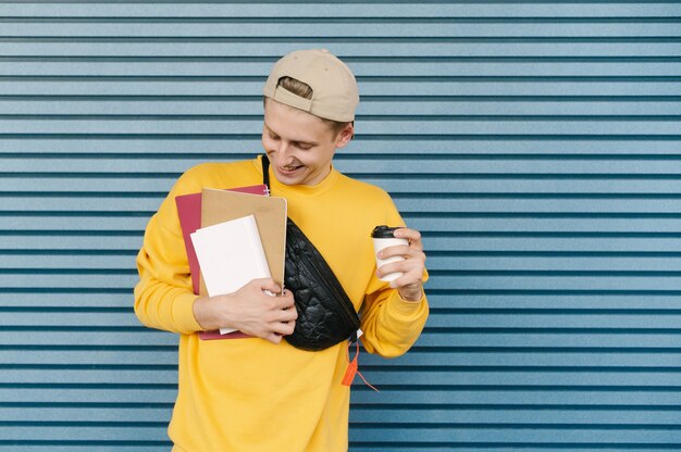 Foto student in een pet en een geel sweatshirt staat