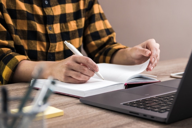 student in geel shirt maken van aantekeningen in haar notitieblok