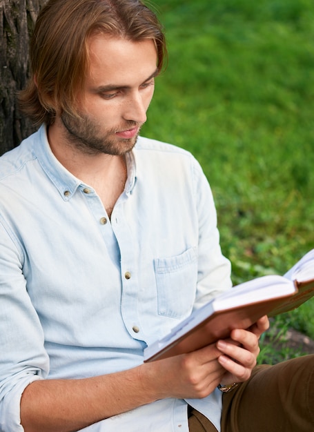 Student in park van campus las een boek