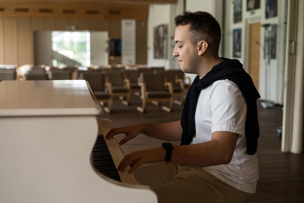 A student at the institute reads a book in between lessons and plays the piano in the classroom