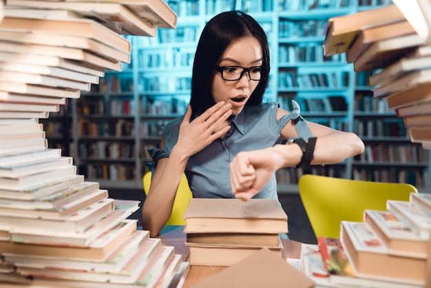 Photo student is looking at watch and confused.