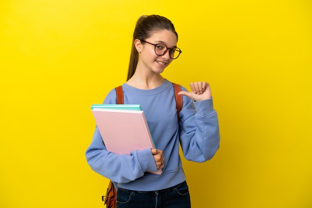 誇りと自己満足の孤立した黄色の背景上の学生の子供の女性