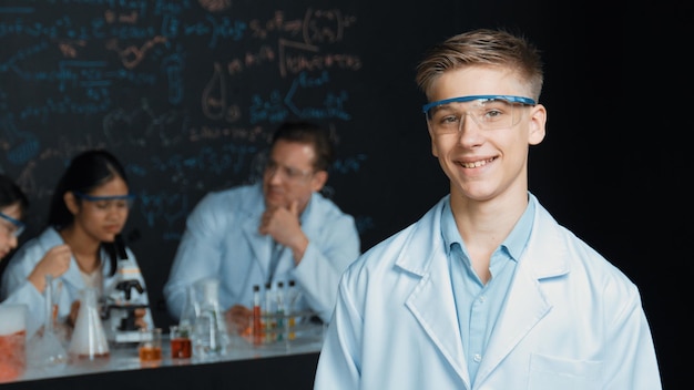 Foto student kijkt naar de camera terwijl een diverse groep experimentele opvoeding doet