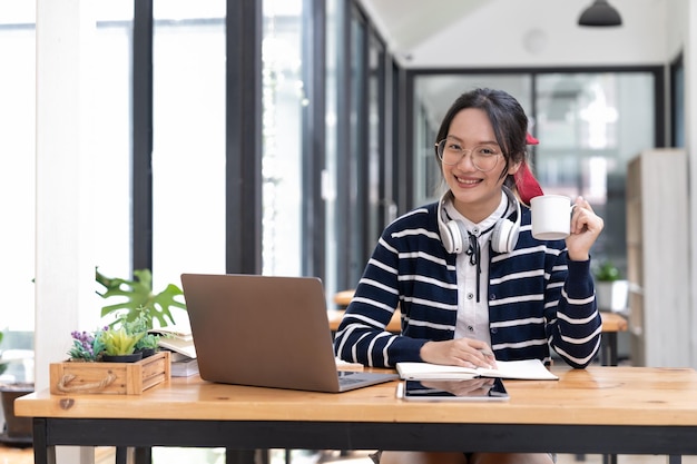 Student learning on laptop indoors educational course or training seminar education online concept Portrait asian woman with modern laptop and headphones learning at home