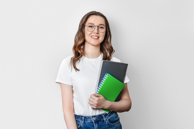 Student meisje met rugzak glimlacht geïsoleerd op een witte achtergrond