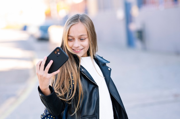 Student meisje op weg naar school met behulp van een smartphone