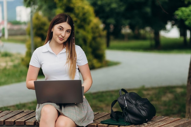 Student meisje werkt met een laptop in een groen park Kopieer ruimte