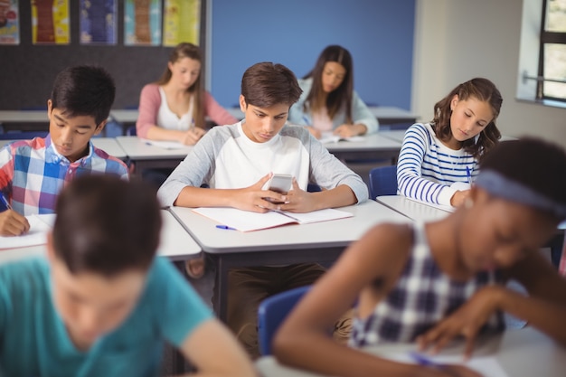 Student met behulp van mobiele telefoon in de klas