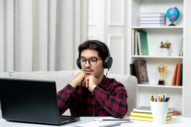 Student online jonge kerel in geruit overhemd met bril studeren op computer luisteren naar leraar