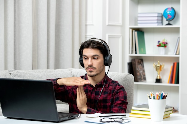 Student online schattige kerel in geruit overhemd met bril die op computer studeert met finishteken