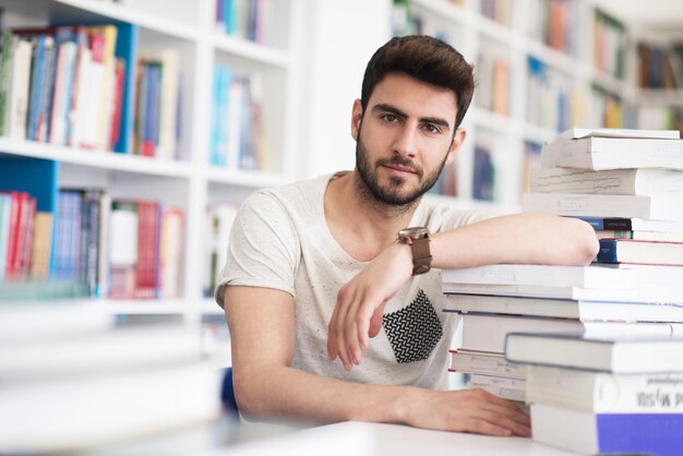 Foto libro di lettura per studenti nella biblioteca scolastica lezioni di studio per l'esame concetto di duro lavoro e perseveranza