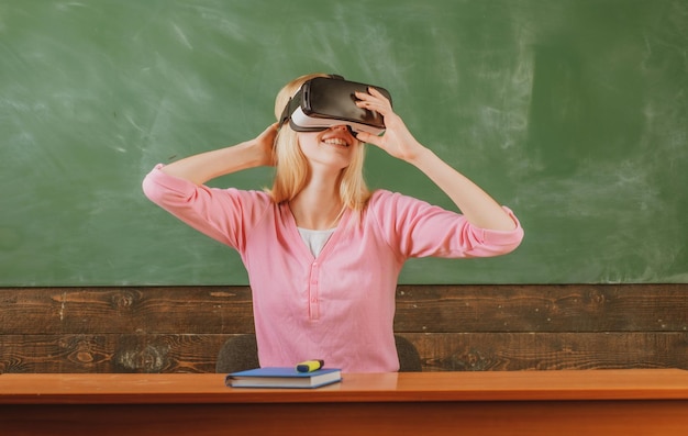 Student reading with vr glasses on a blackboard school girl\
with virtual reality headset education in high school university\
college with future education technology