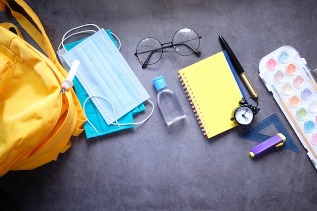 Foto borsa da scuola per studenti con disinfettante, maschera per il viso.