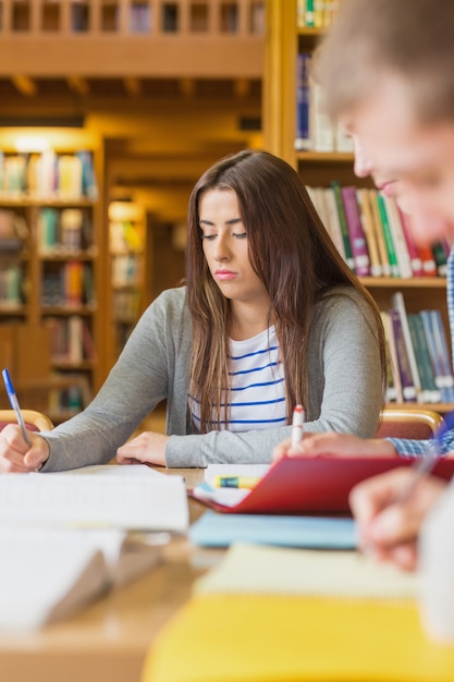 Student schrijven van notities op de balie van de bibliotheek