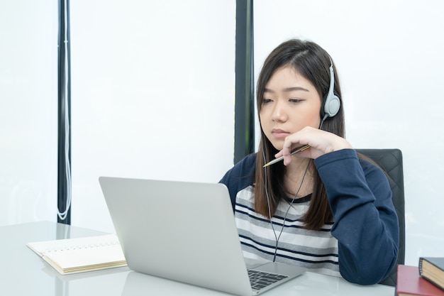 Student sitting in living room and learning online