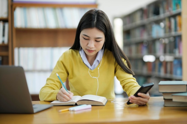 Studente seduto e che studia in biblioteca