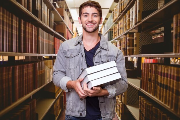 Student smiling at camera in library against close up of a bookshelf