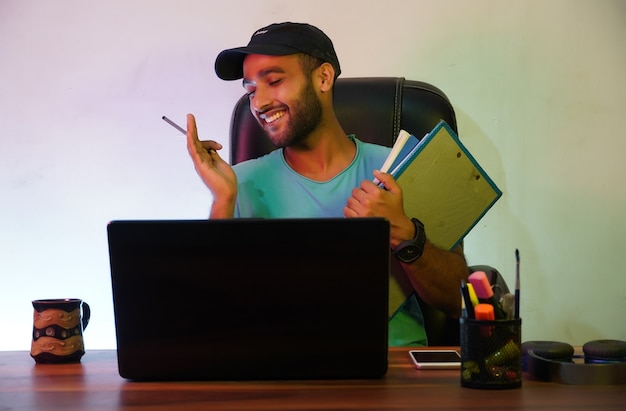 Uno studente sorridente e seduto con un laptop