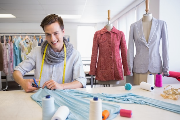 Student snijdende stof met een schaar