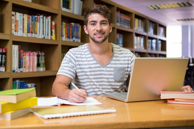 Student studeert in de bibliotheek met laptop