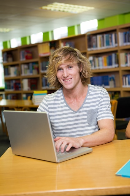 Student studeert in de bibliotheek met laptop