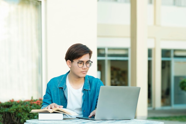 ラップトップを使用して屋外で勉強している学生