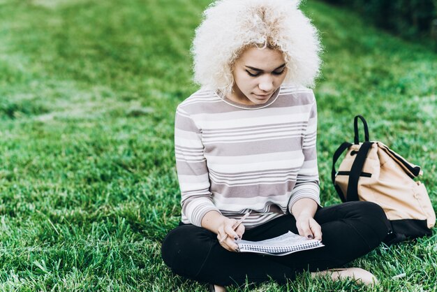 Student studying outdoors on grass