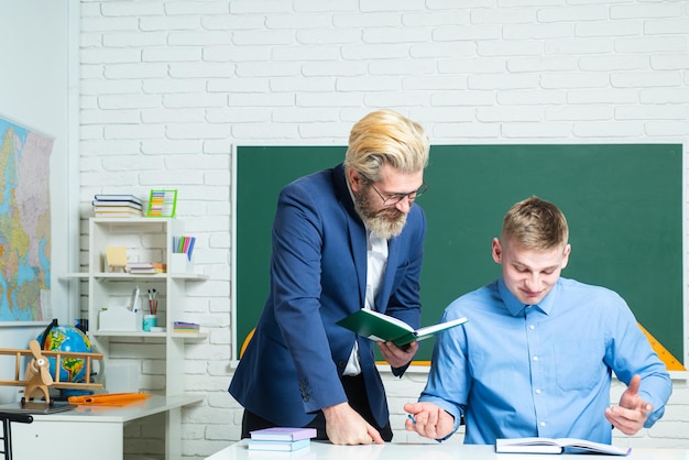 Student and teacher at college Instructor in training class with students Portrait of young teacher helping a student during class