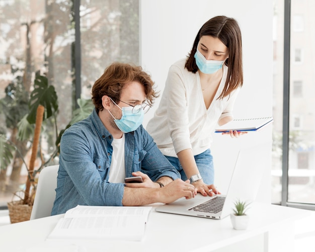 Studente e tutor che indossano maschere mediche