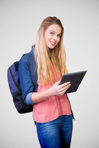 Student using tablet in library  against grey vignette