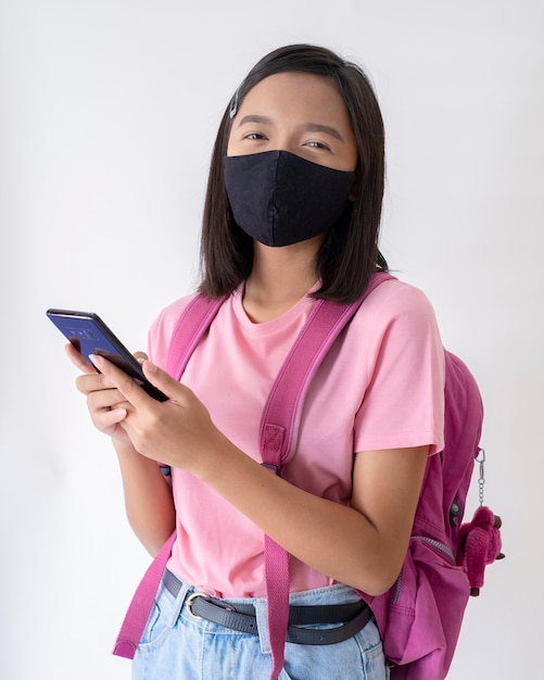 Student with face mask with smartphone wear pink shirt