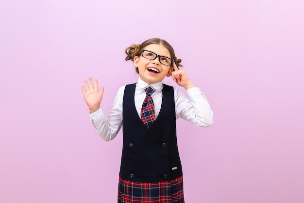 A student with glasses and a tie looks up and smiles. A schoolgirl on an isolated background, copy the space.