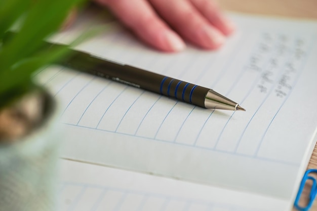 student writes mathematical formulas in a notebook pen and notes