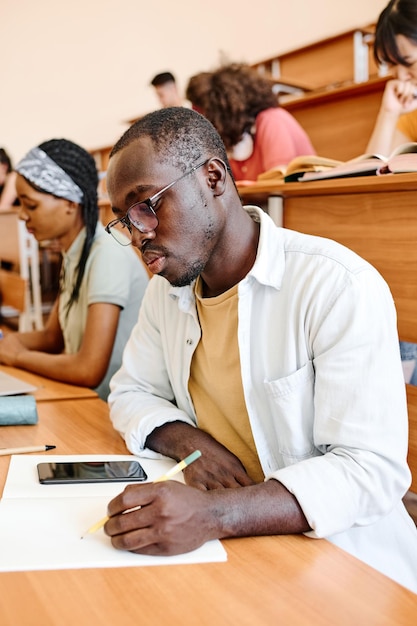 Student writing exam at auditorium of university